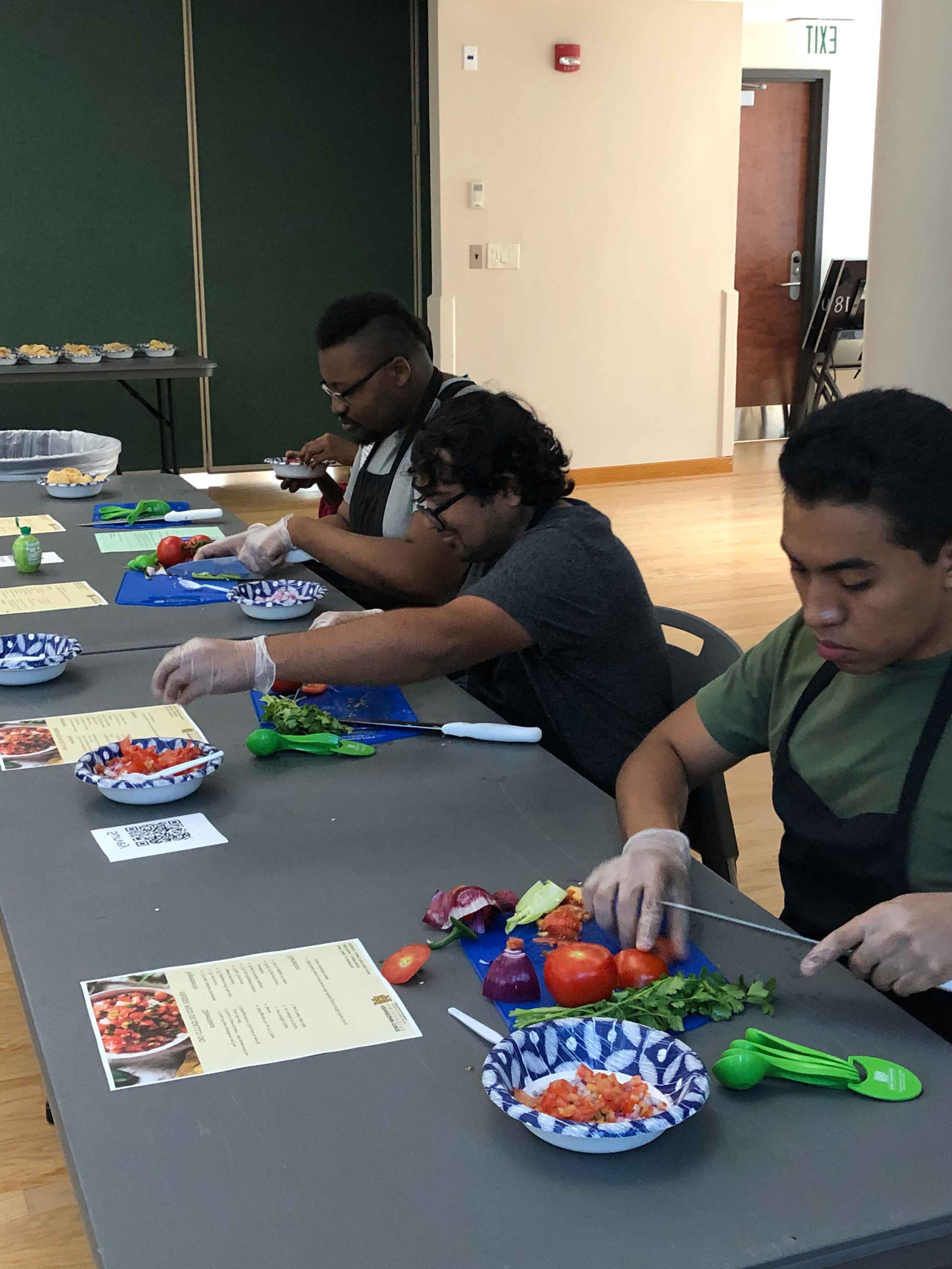  / group of ksu students chopping up vegetables at a ksu event.