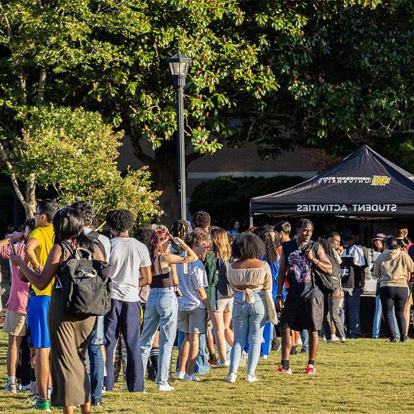 large group of ksu students waiting in line for the student activities tent.